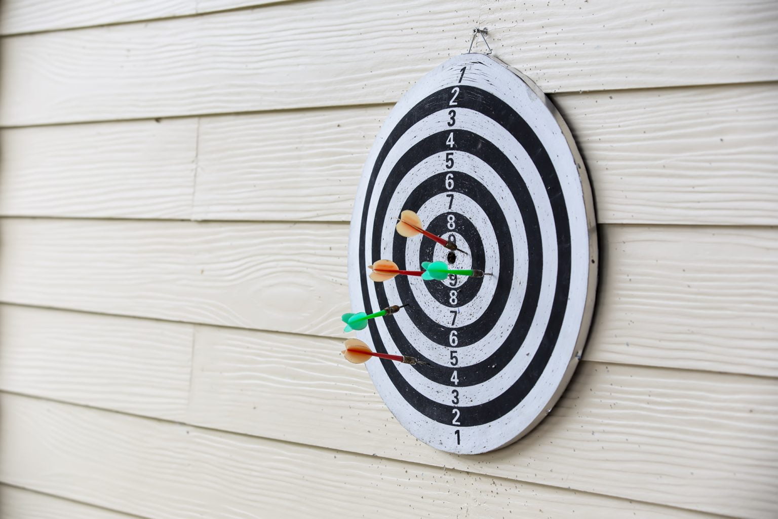 Dart board arrows missed target on wood wall