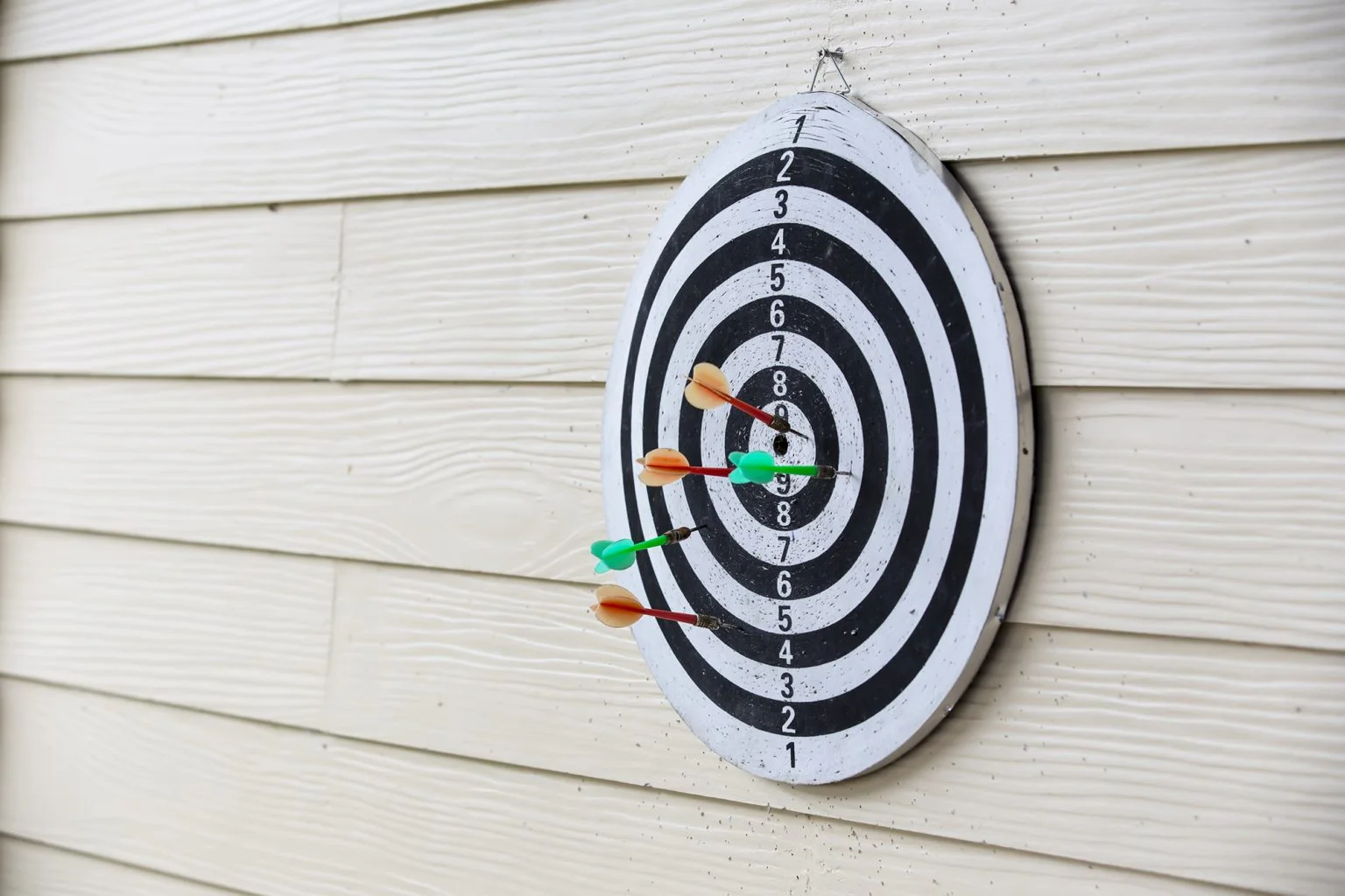 Dart board arrows missed target on wood wall