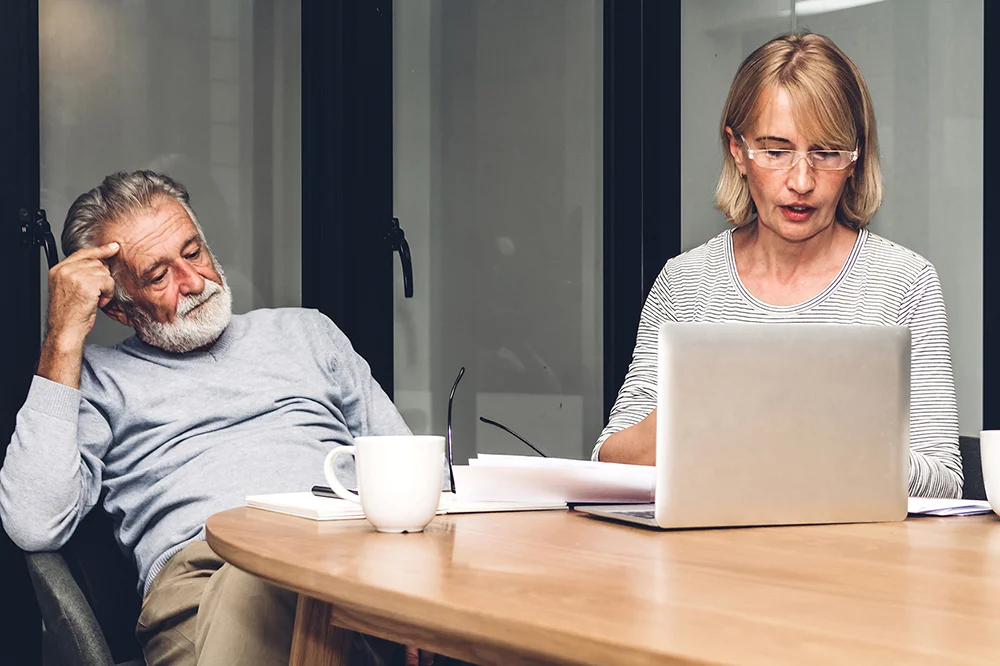 Senior couple reading documents and calculating bills