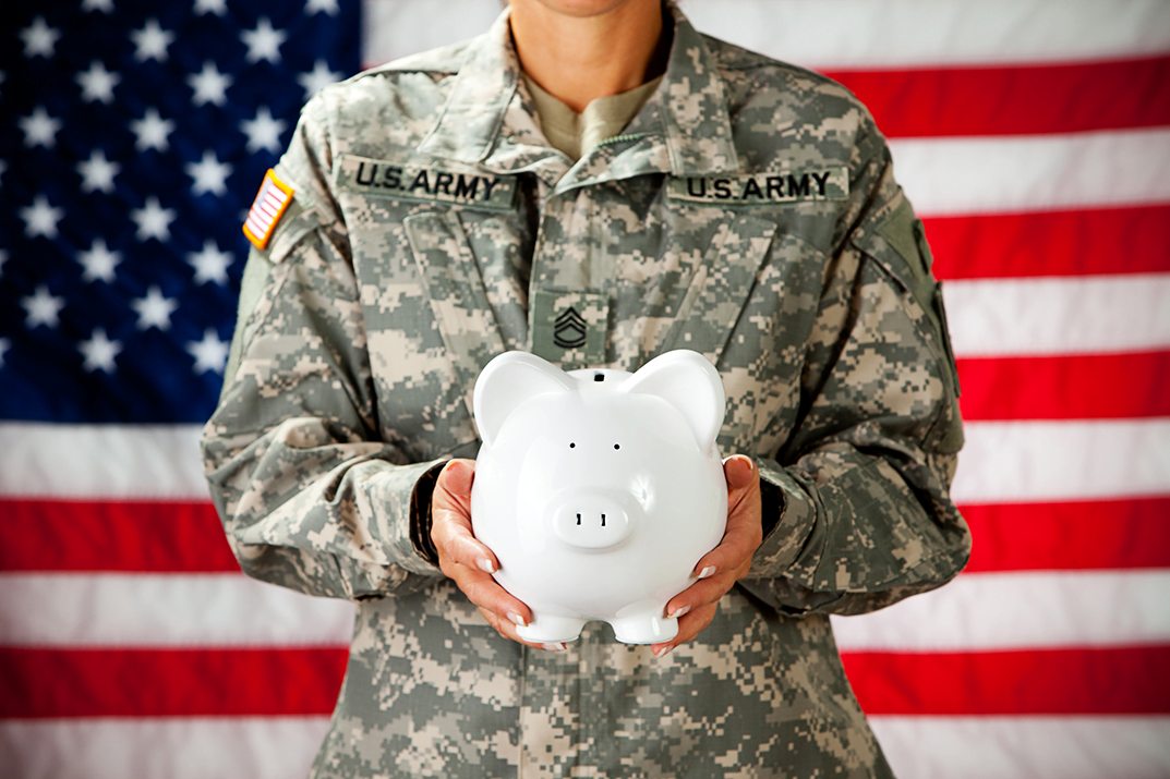 Female soldier holding a piggy bank