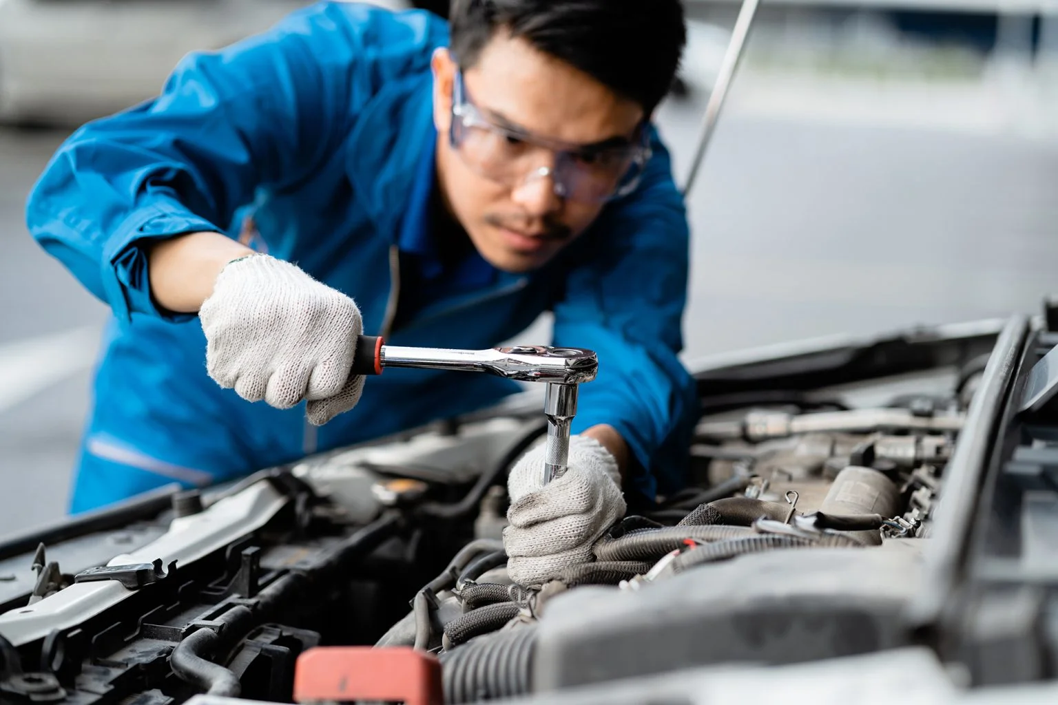Close-up of a car mechanic repairing a car in a garage