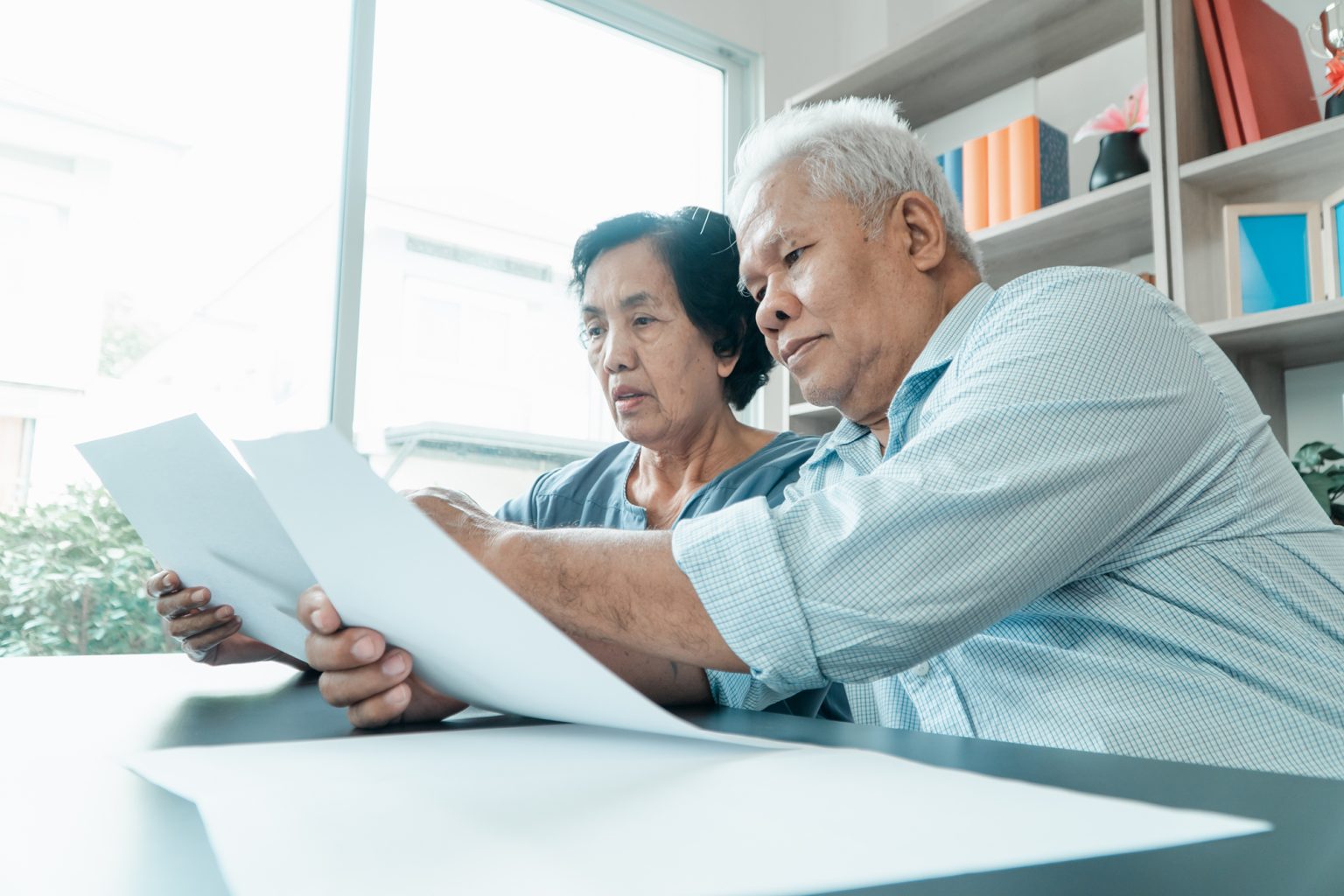 Senior couple looking over documents at a table