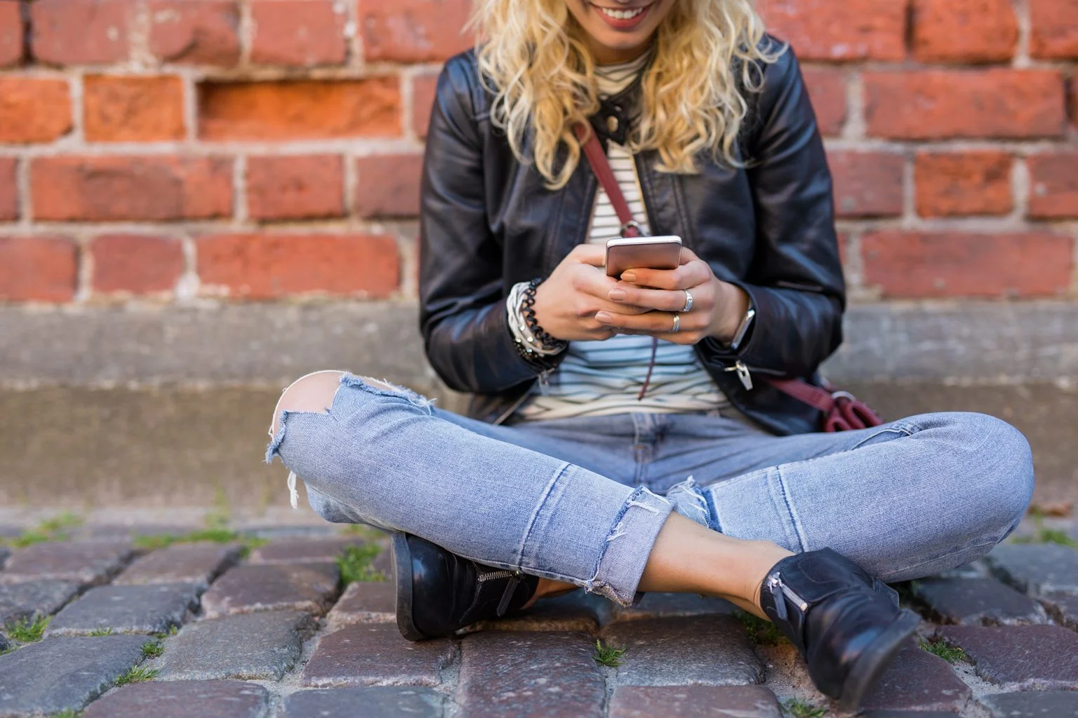 Hipster sitting on the ground and using phone