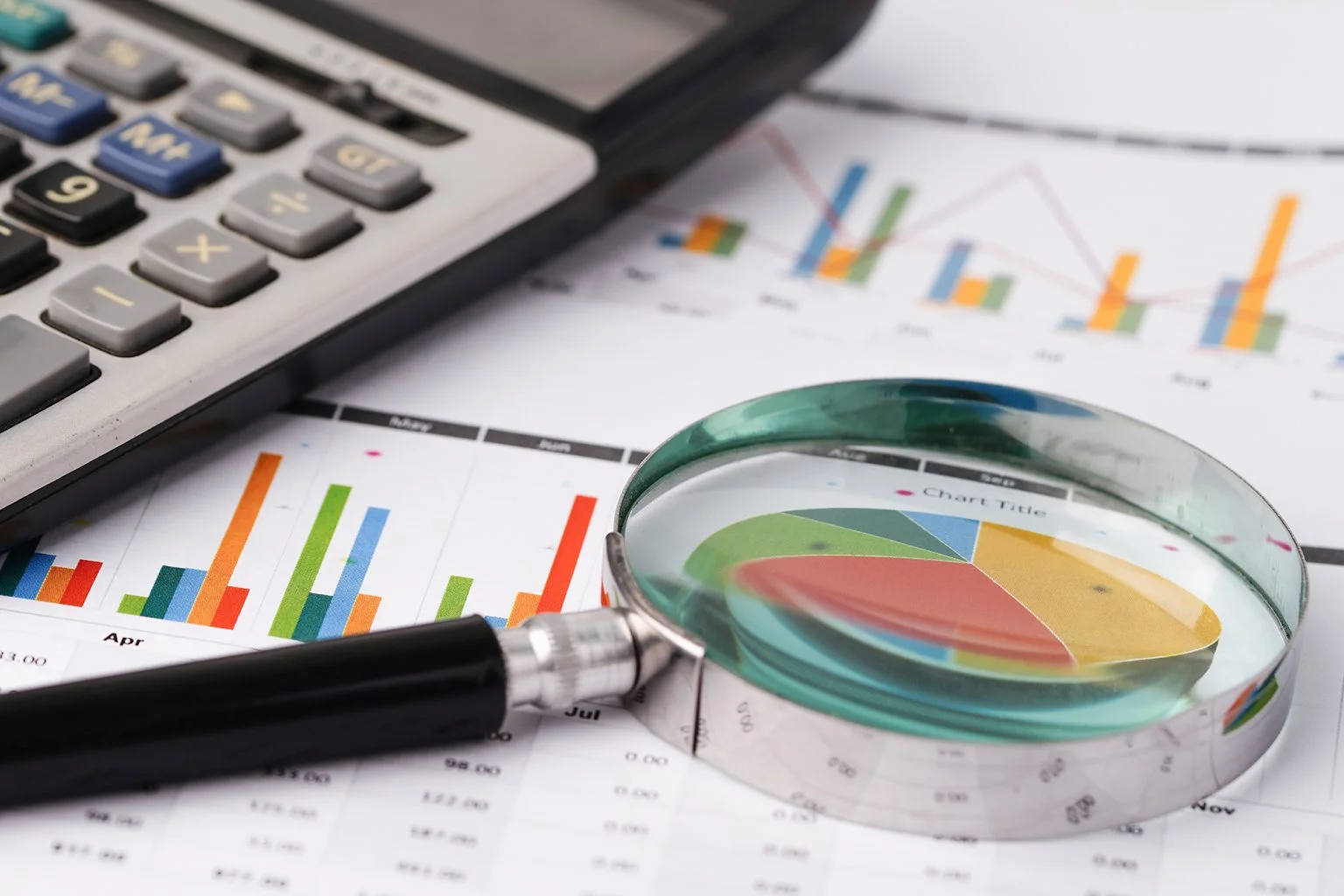 Magnifying glass on charts graphs paper