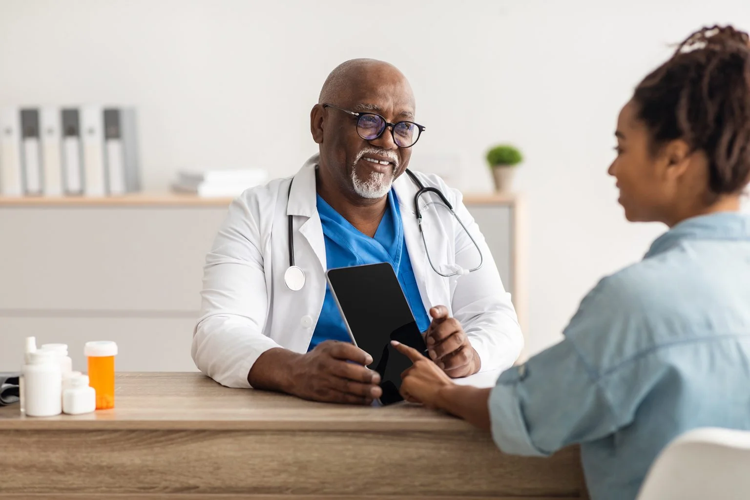 Older male doctor explaining treatment plan to female patient