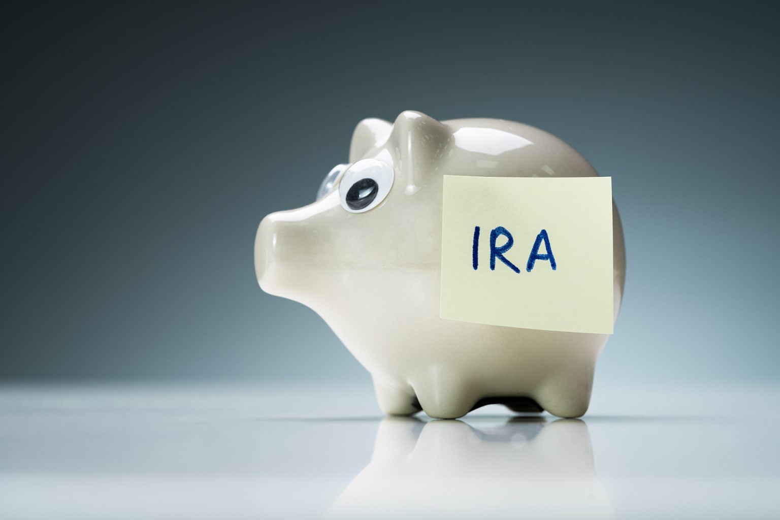 Piggy Bank on a Desk with a Post-It that says IRA