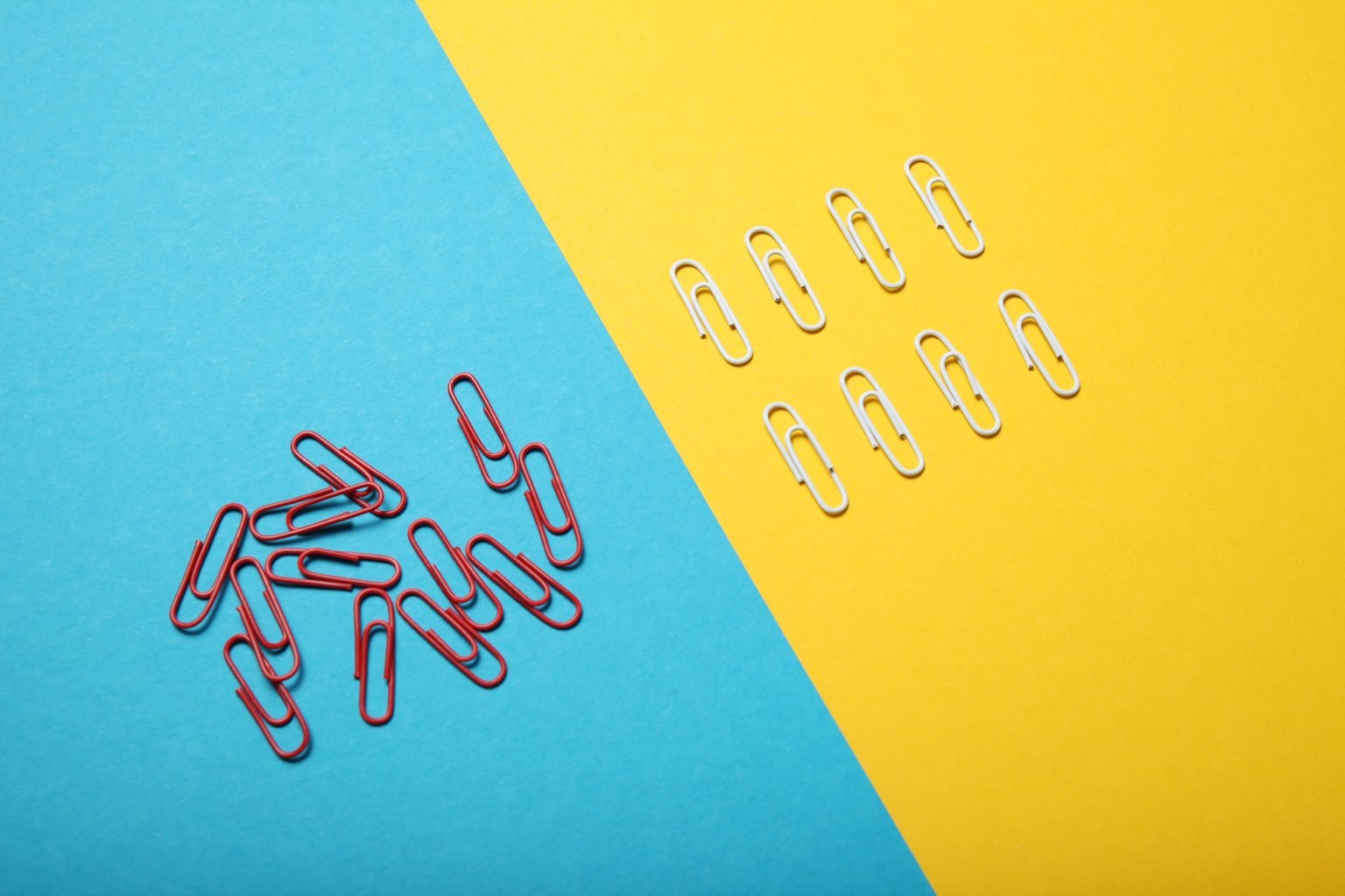Two groups of paperclips, the left is a mess and the right is neatly organized