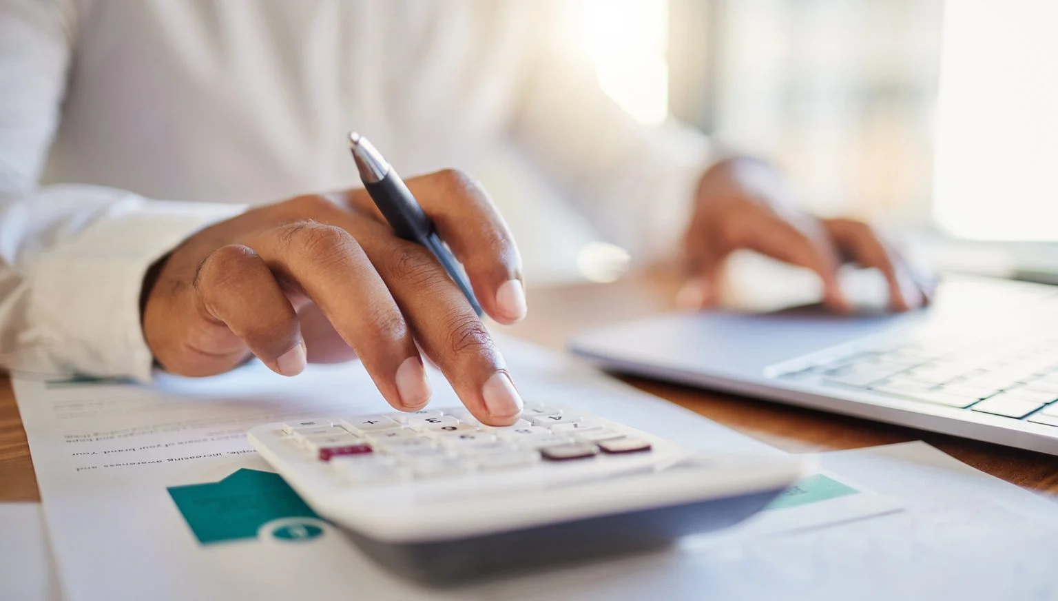 a man on a computer and calculator working out his business budget strategy