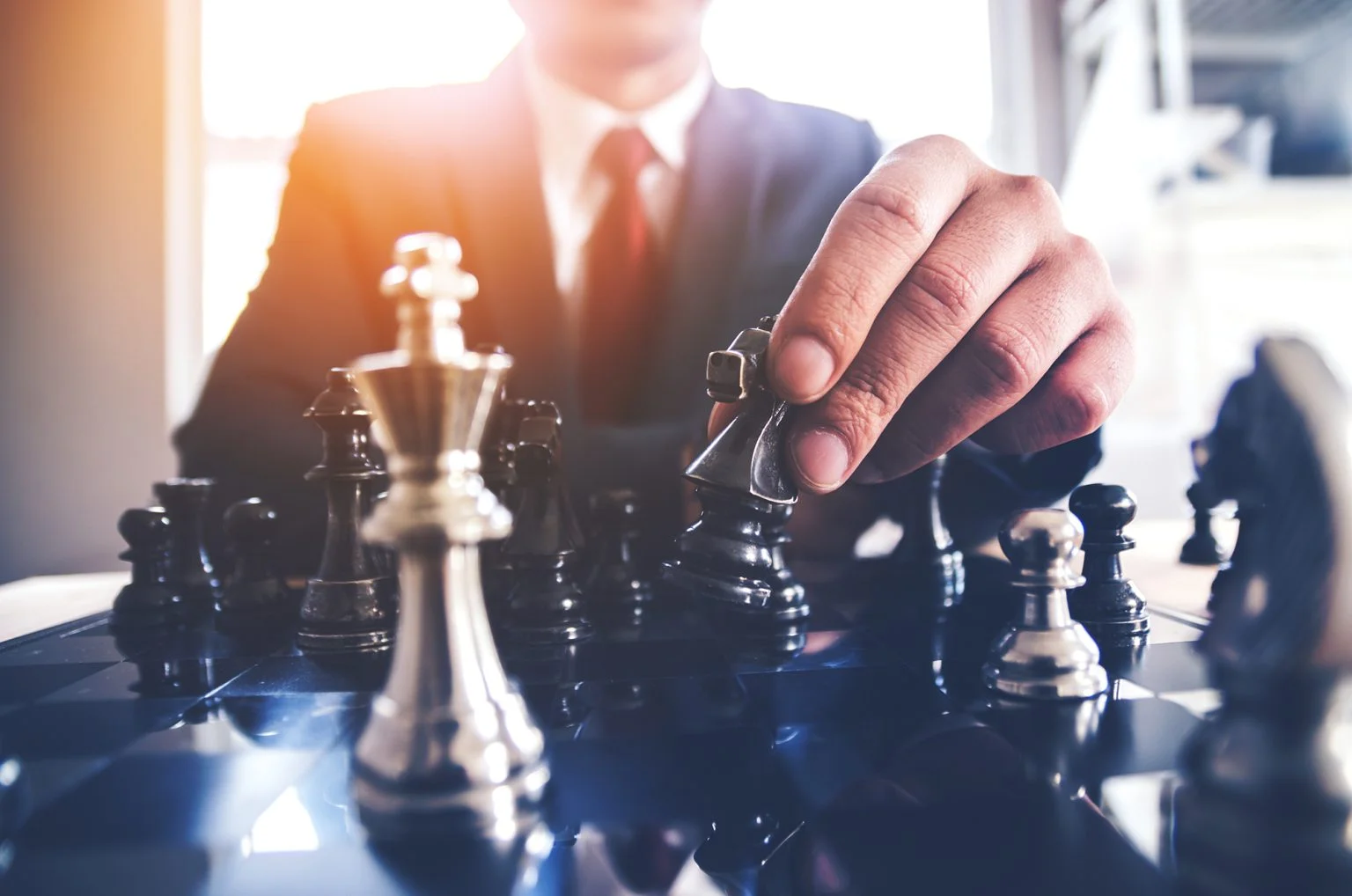 Detail of a hand making the first move in a chess game