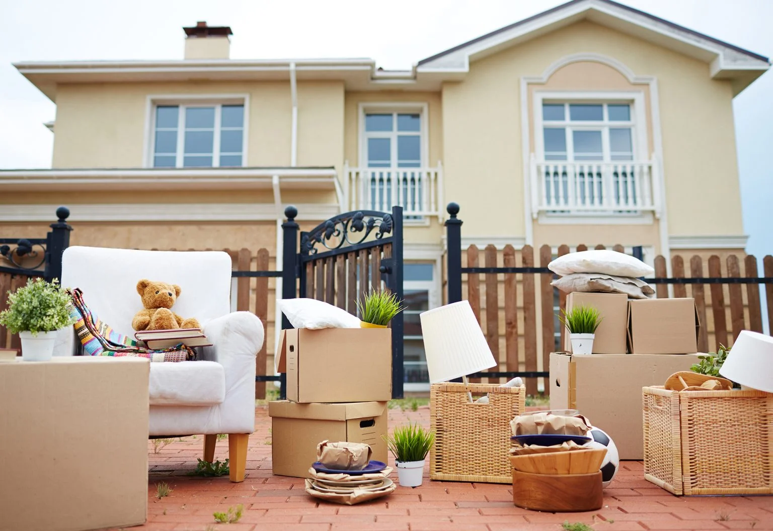 Moving boxes and furniture in front of yellow house