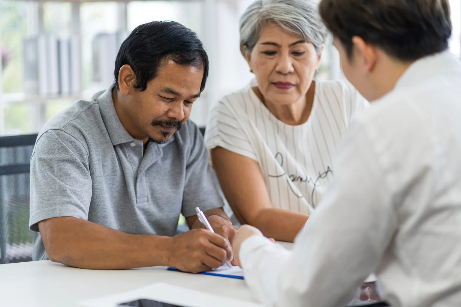 Older couple signing documents in an office