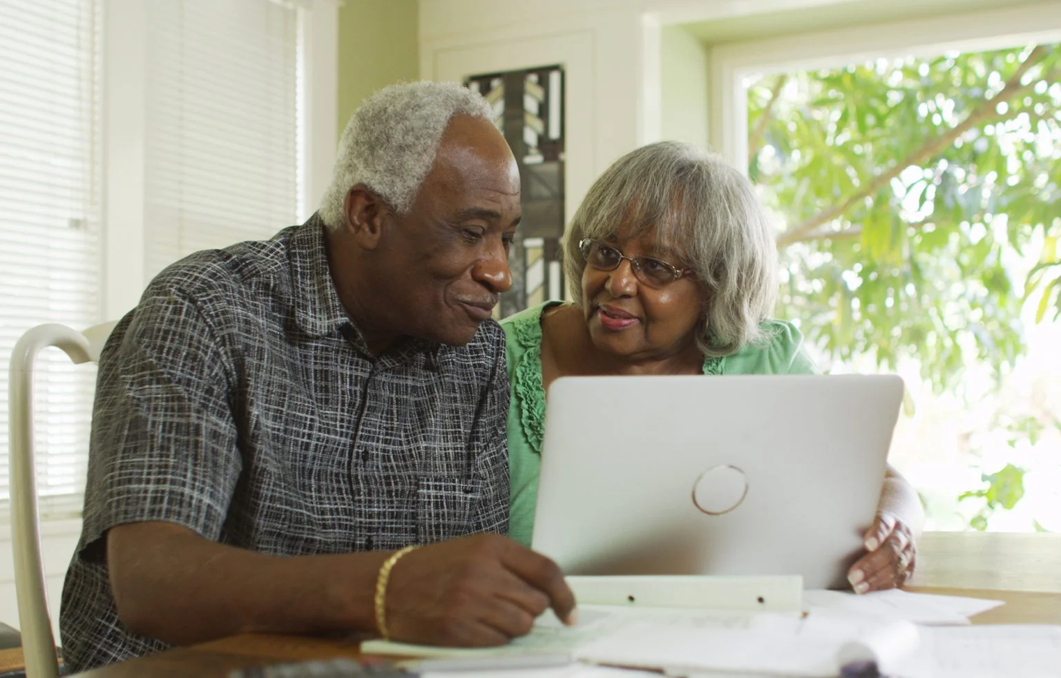 Senior couple on a laptop computer at the kitchen table