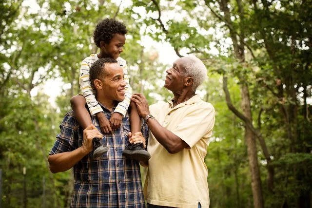 Smiling multigenerational family standing in forest