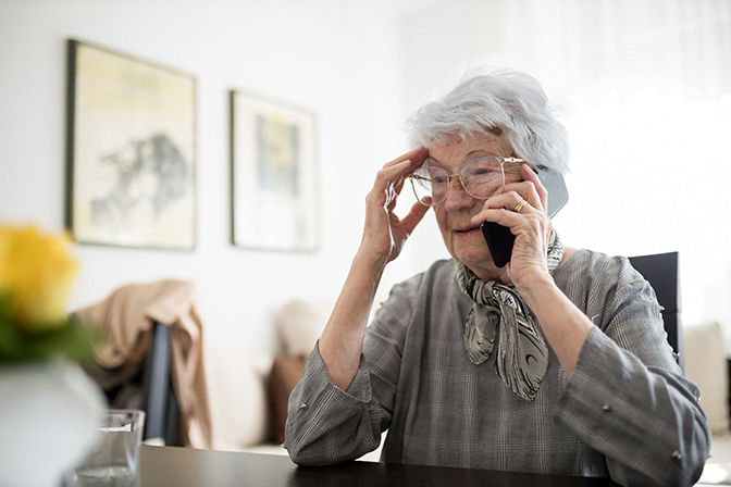 Senior Caucasian woman talking on a phone in her home stock photo