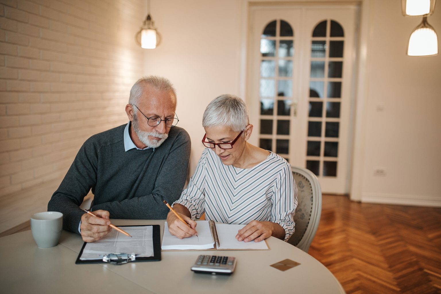 Elderly couple looking over finances at the kitchen table