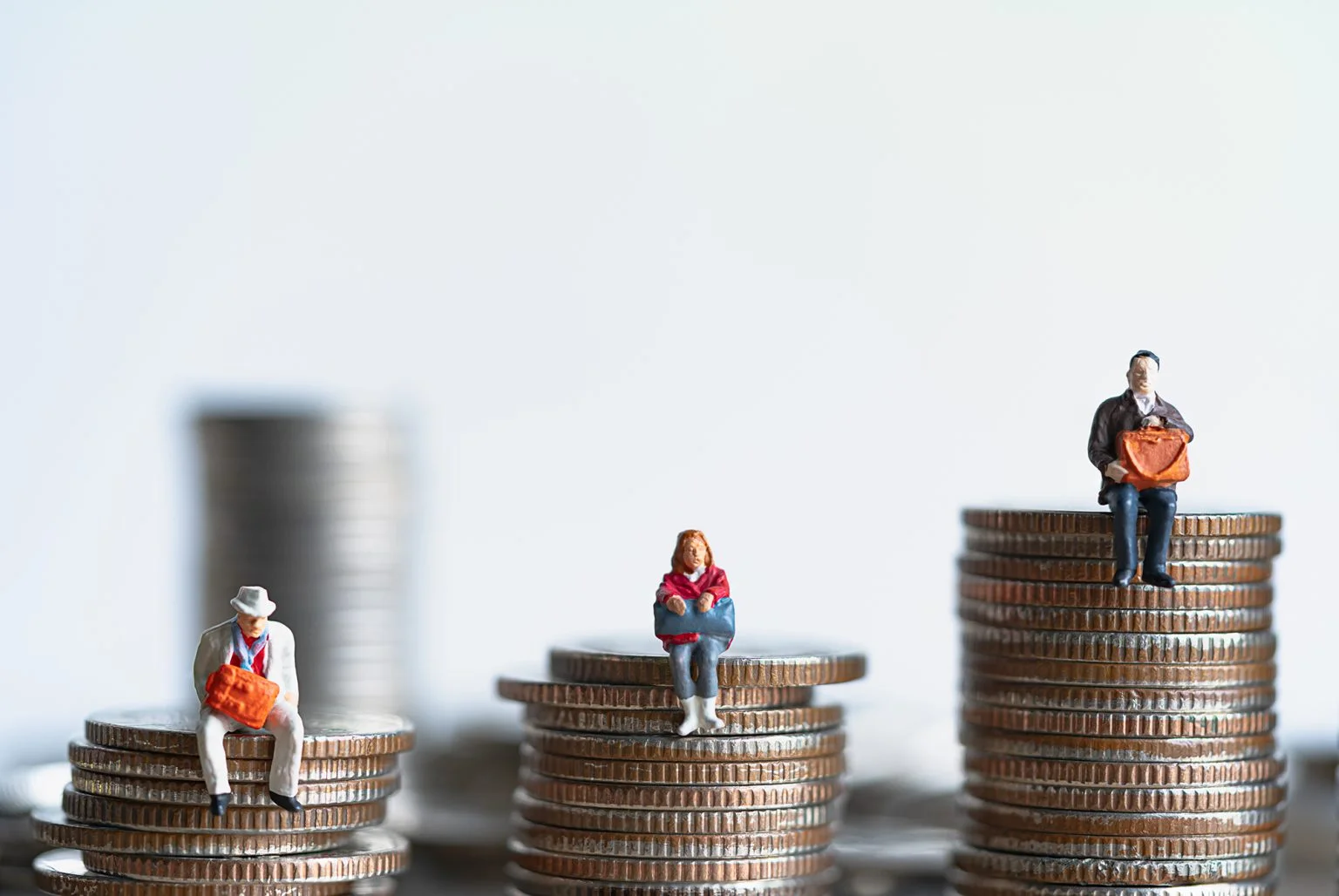 Miniature people_Elderly people sitting on different sized coins stacks