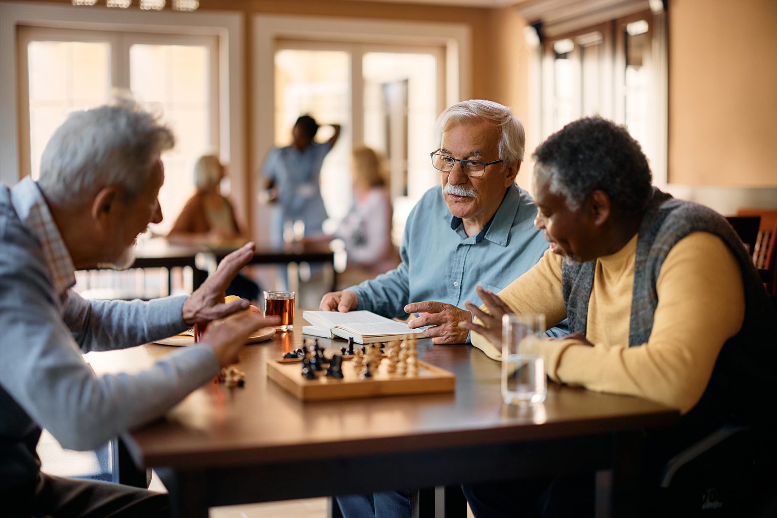 Senior man talking to his friends who are playing chess