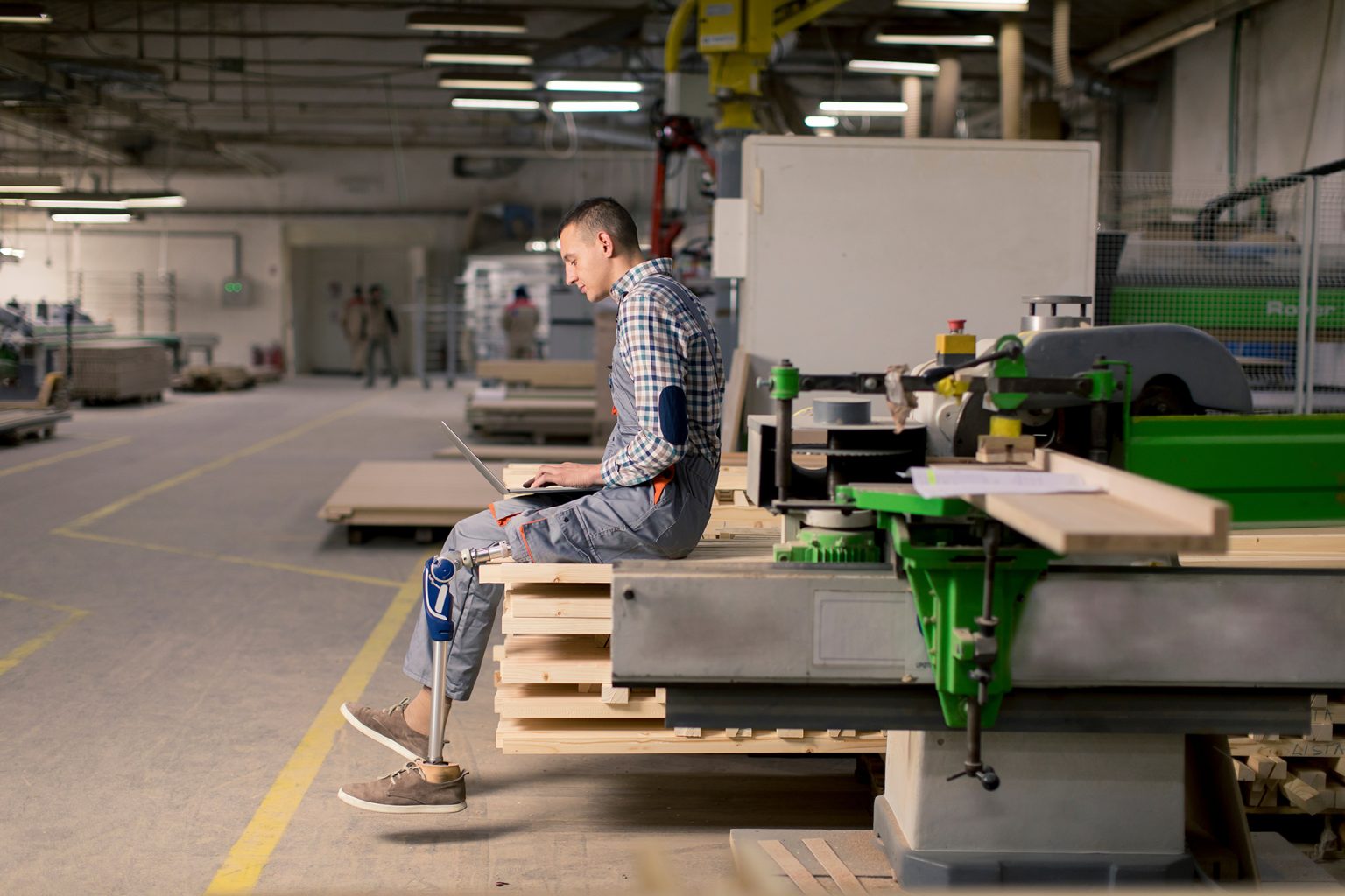 Disabled young man with an artificial leg is working at the furn