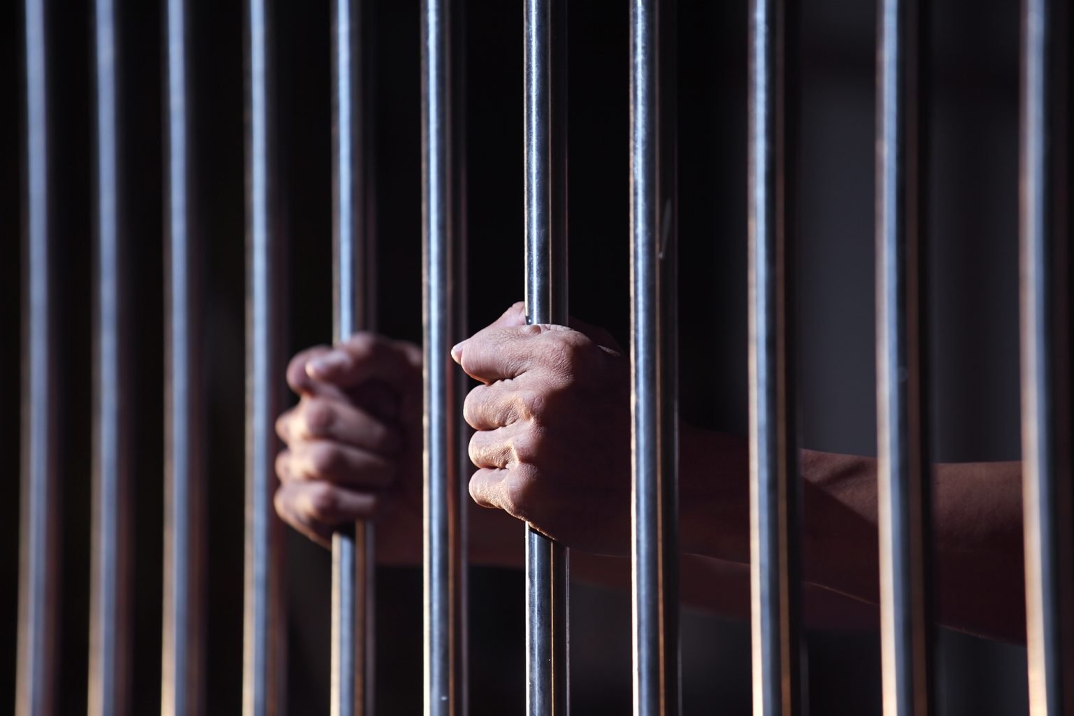 prisoner hands on jail bars