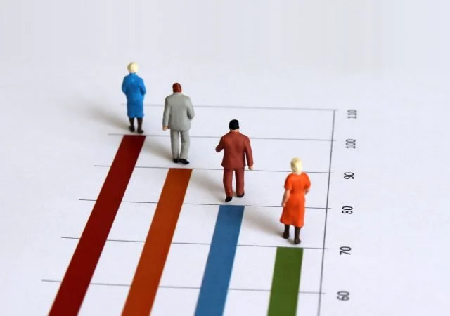 Miniature old people walking on the bar graph