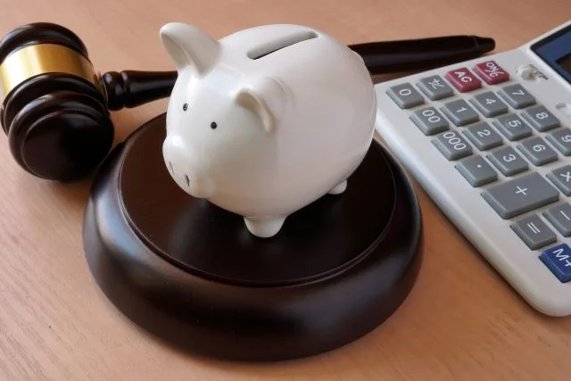 Piggy bank, gavel and calculator on a table