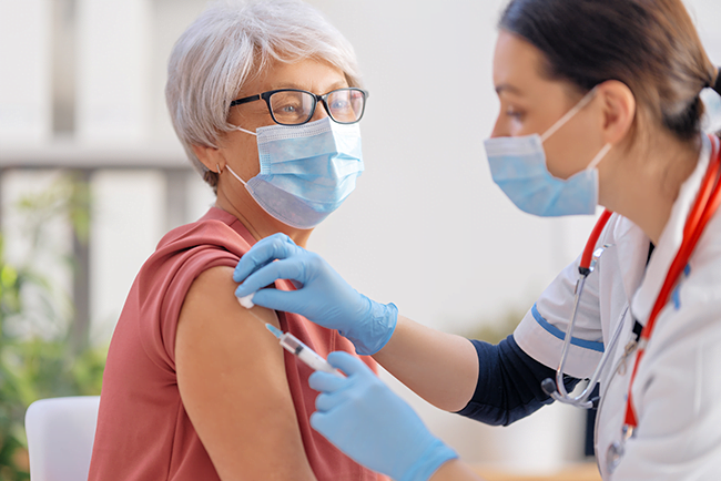 Doctor vaccinating a senior woman
