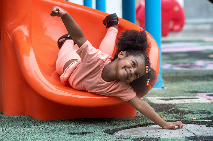 A young girl going down a slide