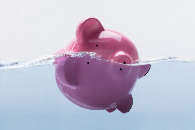 Drowning piggy bank in water
