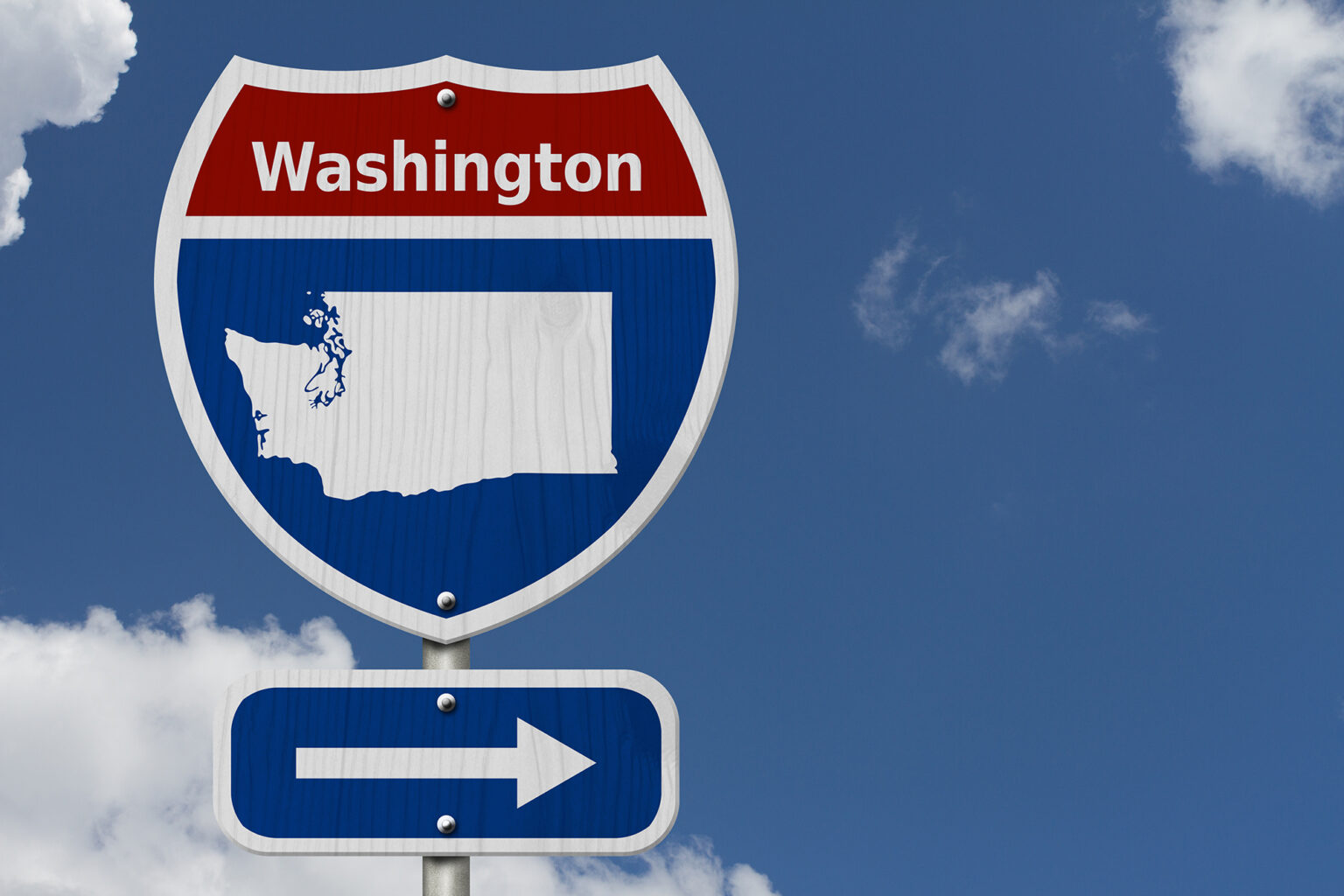 Road sign that says Washington which an image of the state and an arrow pointing to the right with a blue sky in the background