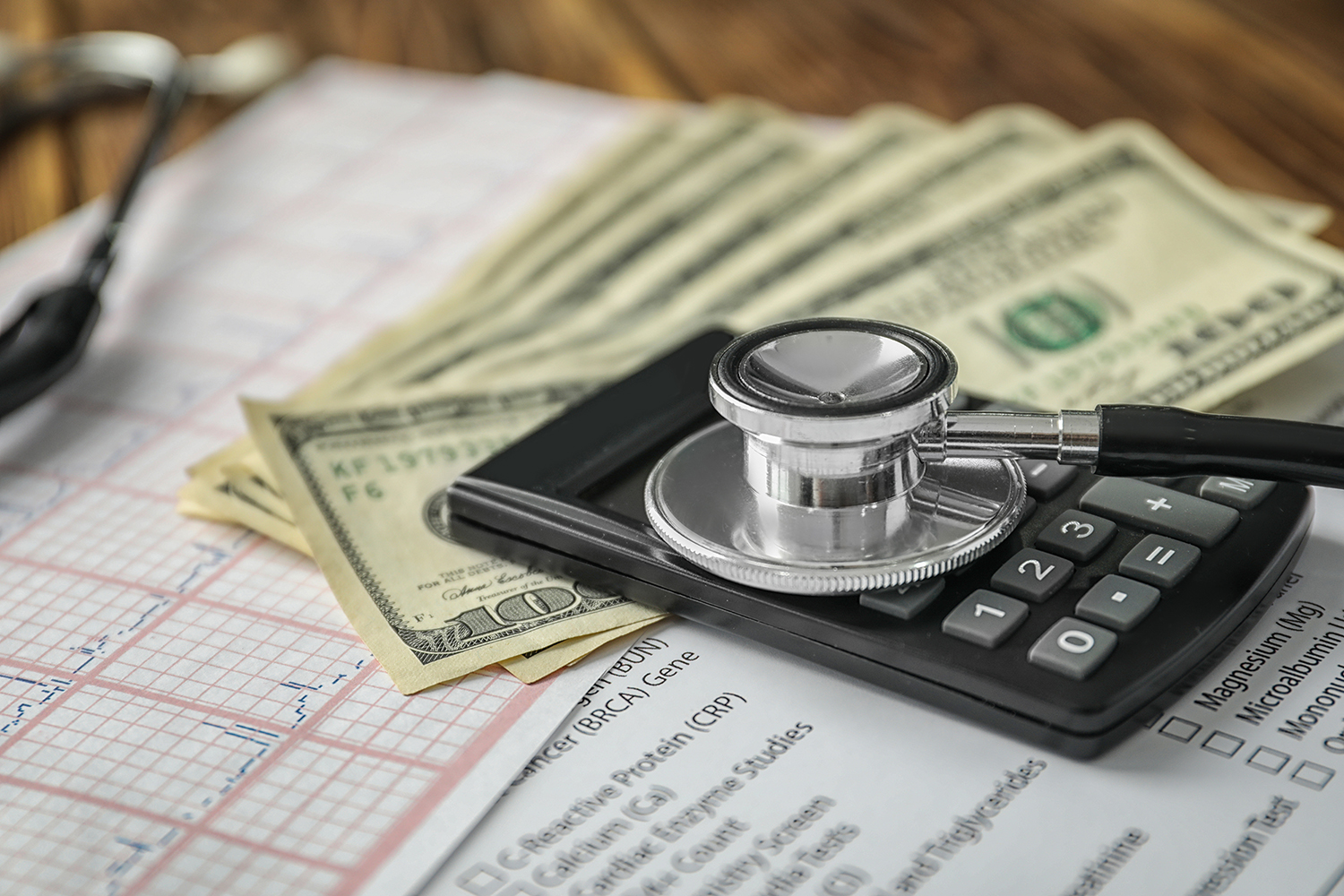 Stethoscope with money and calculator, closeup. Health care conc