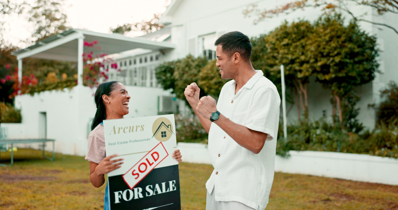 Excited and couple with sold sign