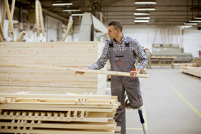 Man with one leg working in a factory