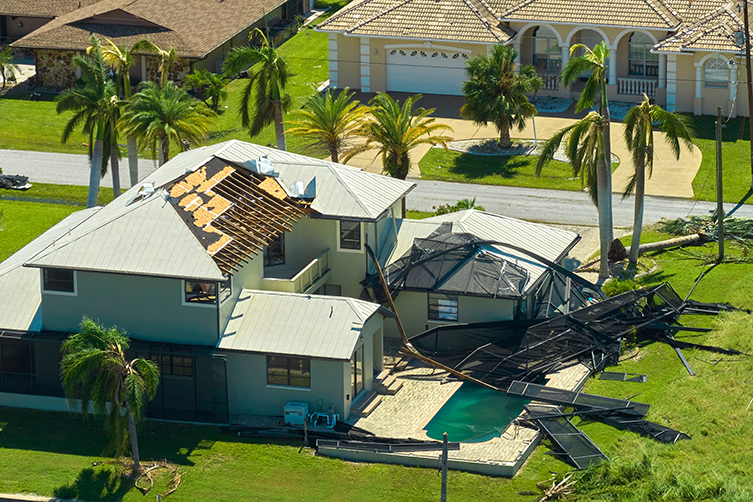 Hurricane Ian destroyed swimming pool lanai enclosure on house yard in Florida residential area.