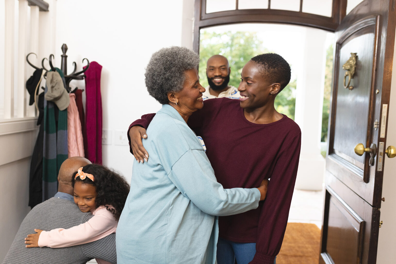 happy multi generation african american family entering house and welcoming each other