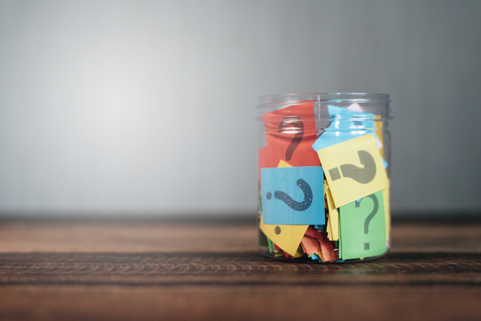 Colorful,Paper,With,Question,Mark,In,A,Plastic,Jar,On