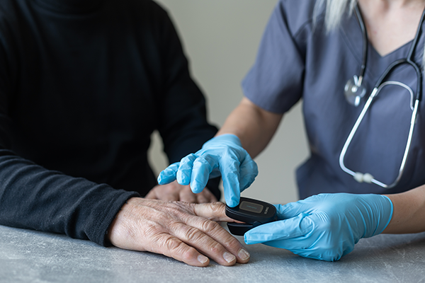 Elderly people measuring their pulse with their fingertips at a long-term care facility