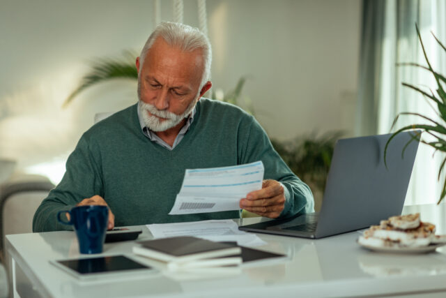 Older man paying monthly bills