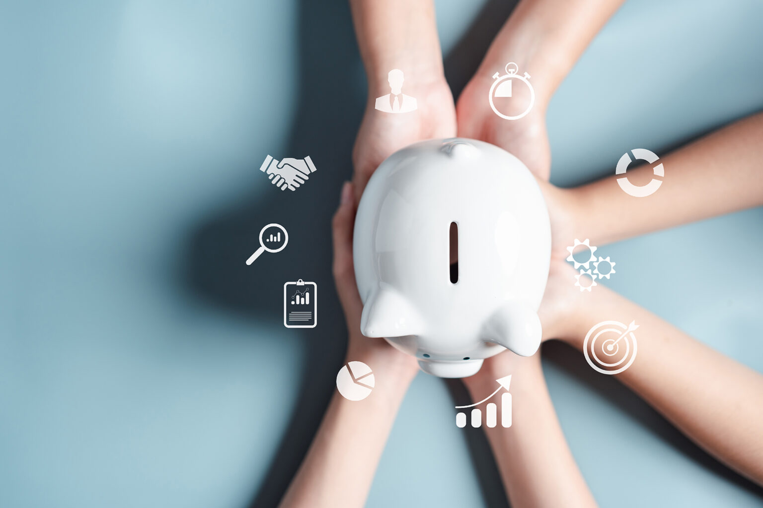 Bird's eye view of three sets of hands holding a white piggy bank surrounded by financial icons