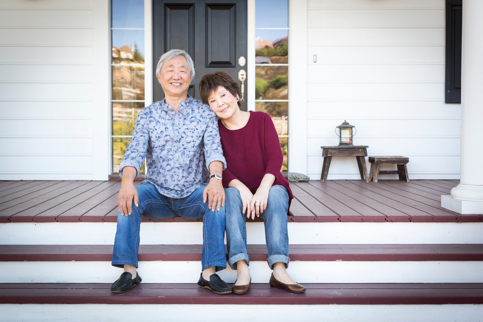 Senior Couple Sitting on Front Steps of Their House