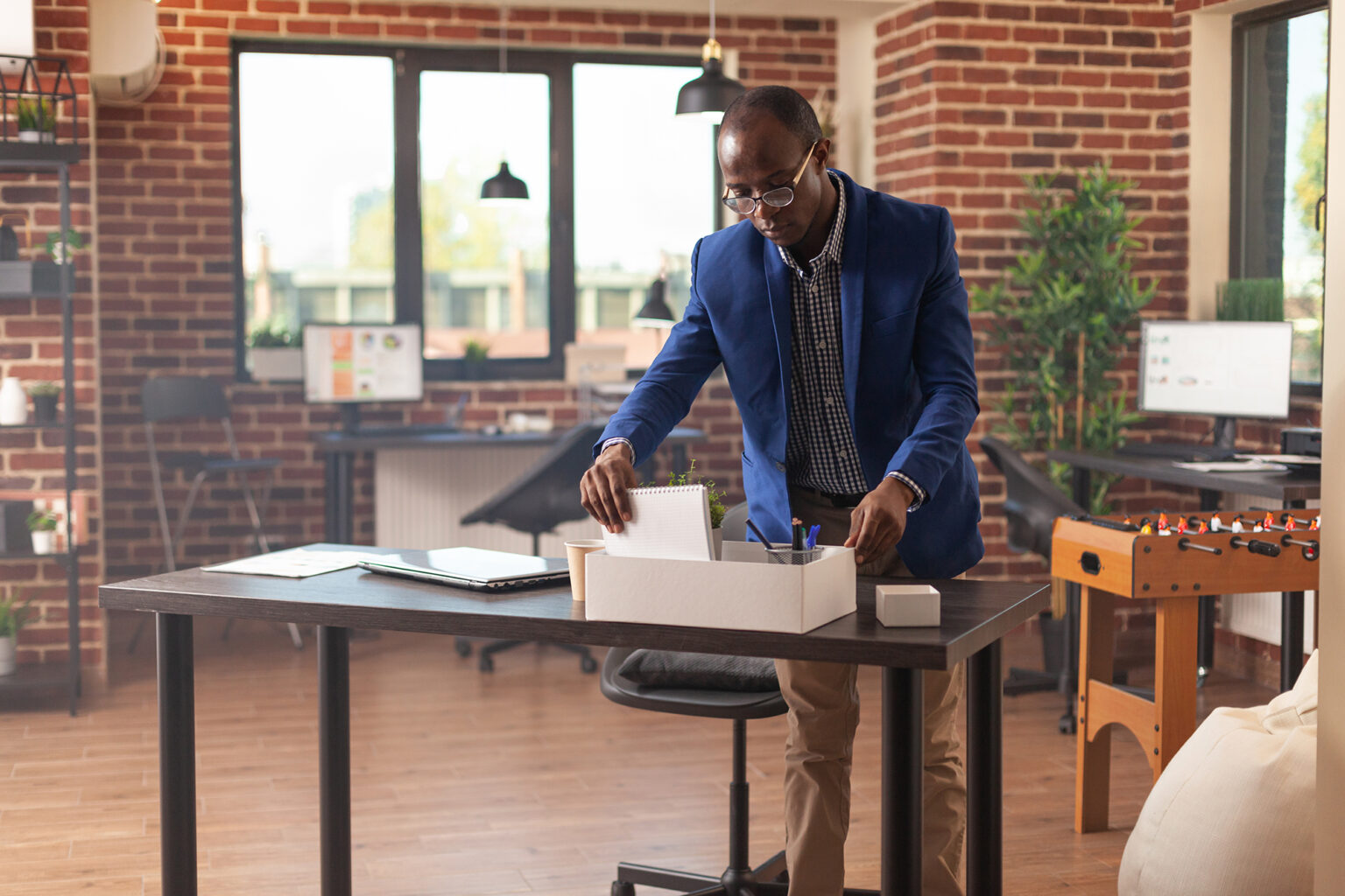 Person getting fired and gathering belongings in box to leave business job