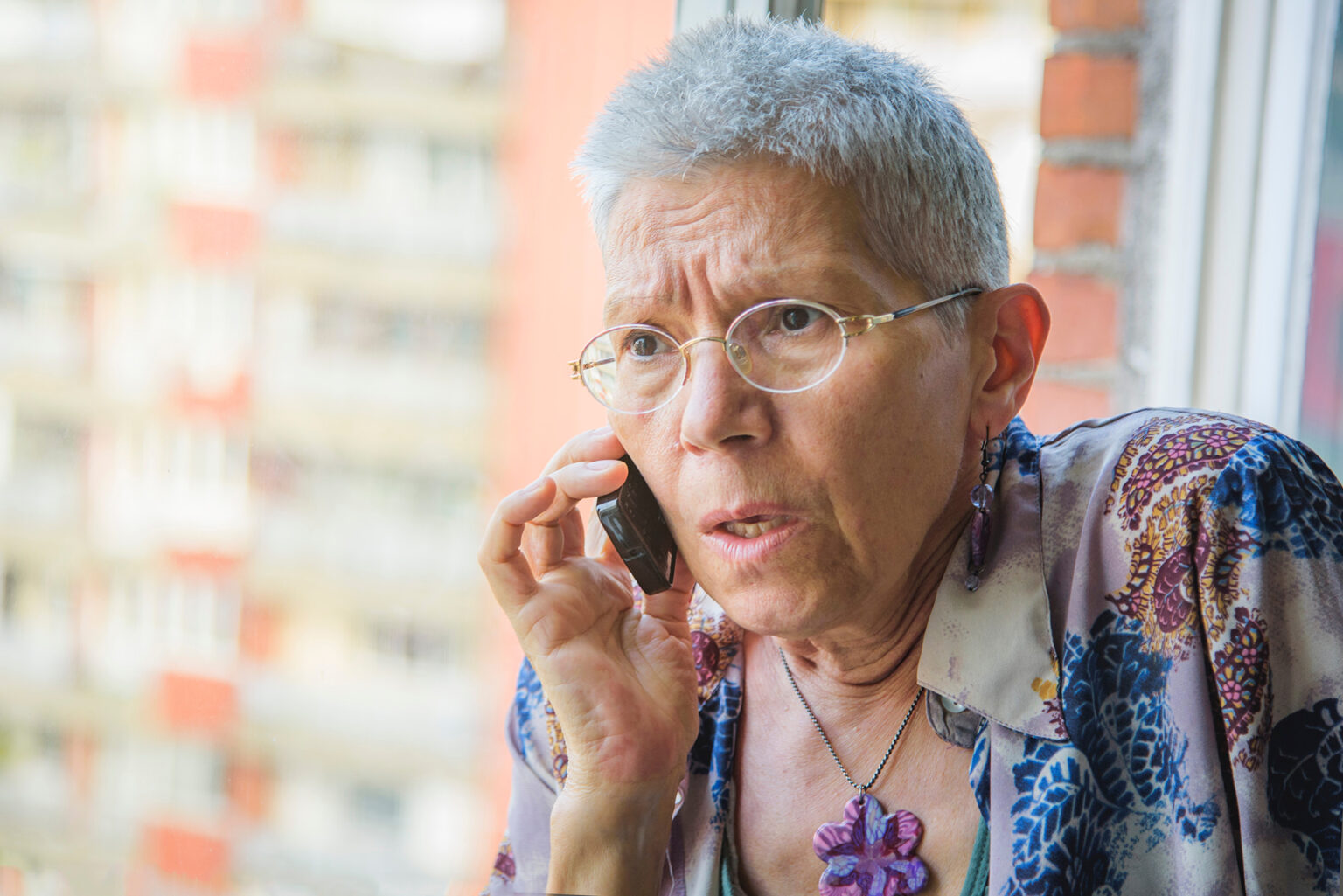 Scared older woman getting news from a cell phone