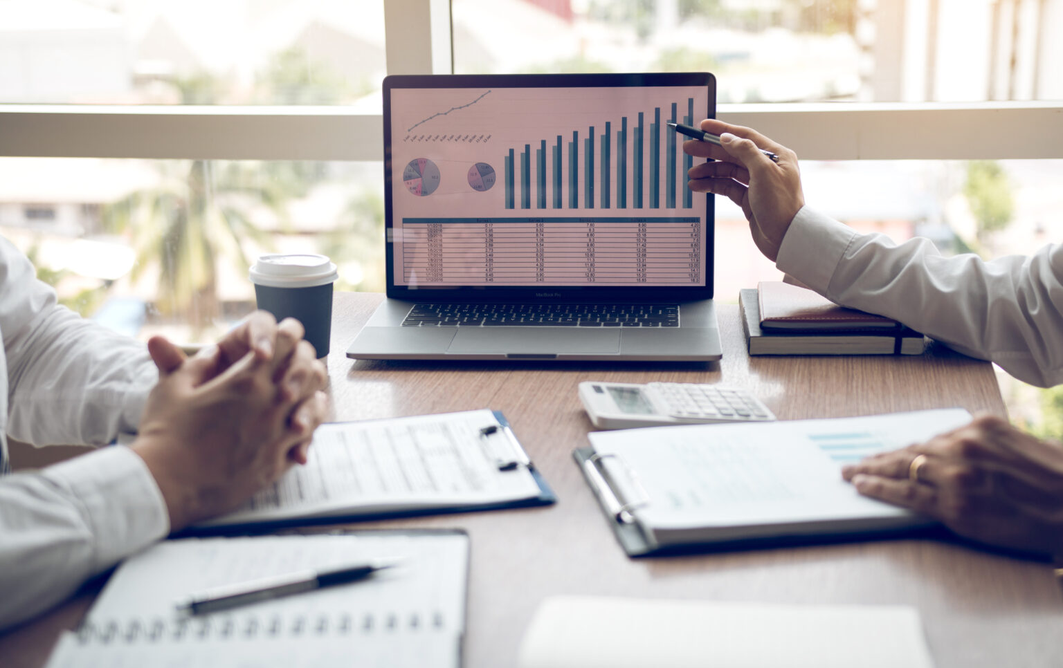 manager is explaining about the company cost graph on the laptop computer for employees to listen to and share the analysis together.
