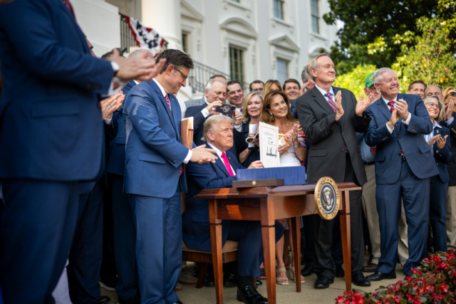 Donald Trump signing the Big Beautiful Bill into law with Congressional leaders clapping