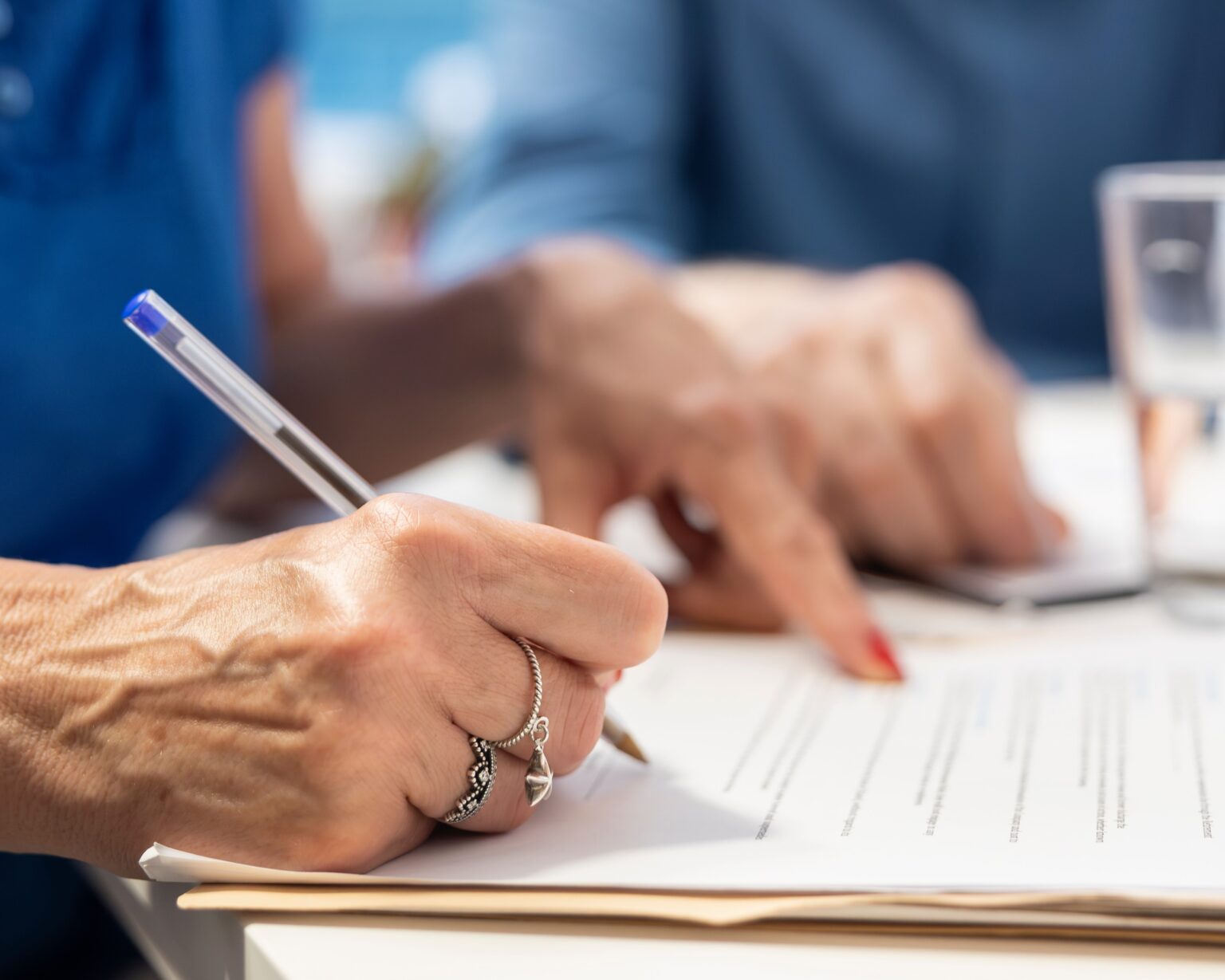Mature person signing the financial contract in modern office