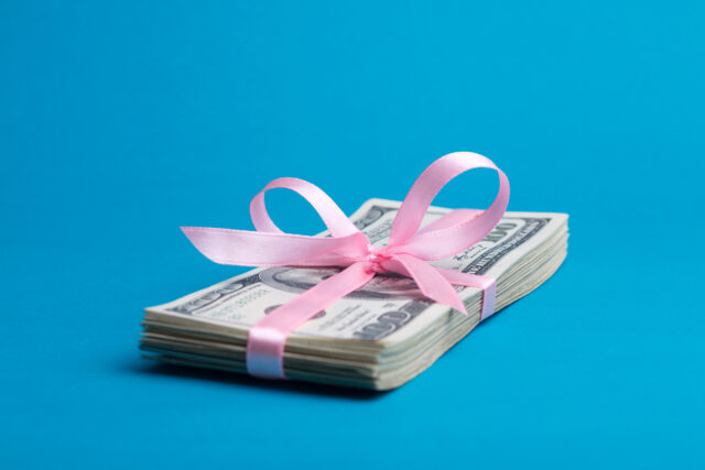 a bundle of dollars tied with a pink ribbon