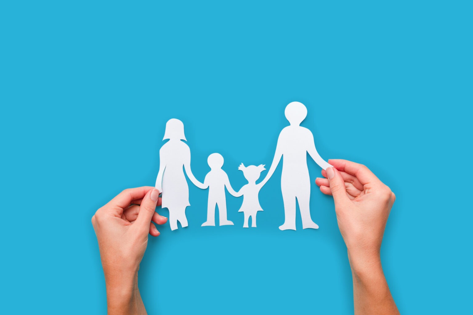 Paper family in hand isolated on blue background