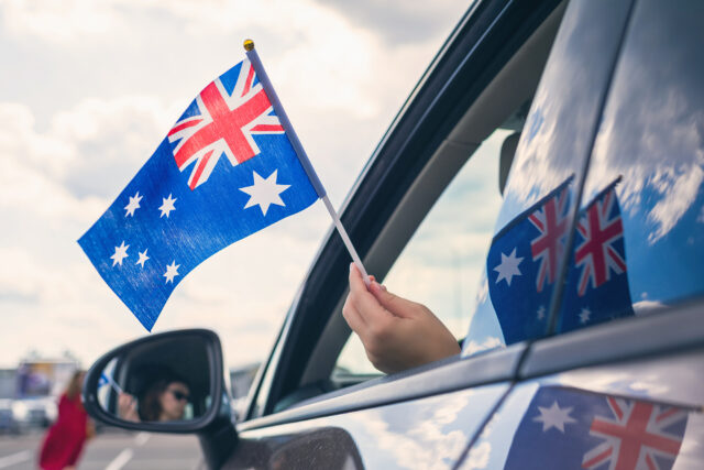 Girl Holding Flag of Australia from the open car window