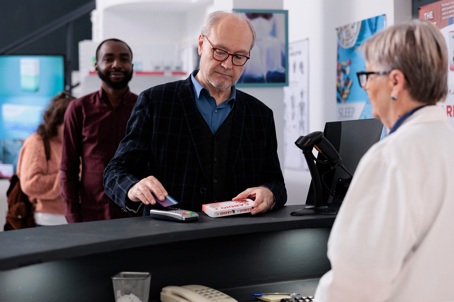Senior person paying for medications with credit card at a pharmacy