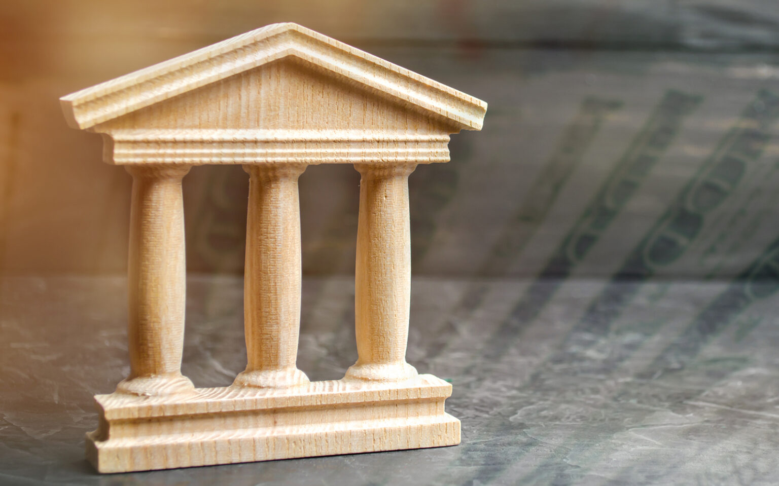 Wooden government building on a background with translucent 100 dollar bills