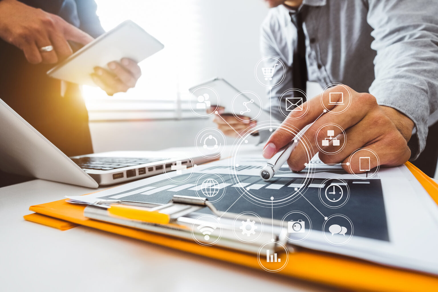 Two business people working at a desk with charts and infrastructure icons